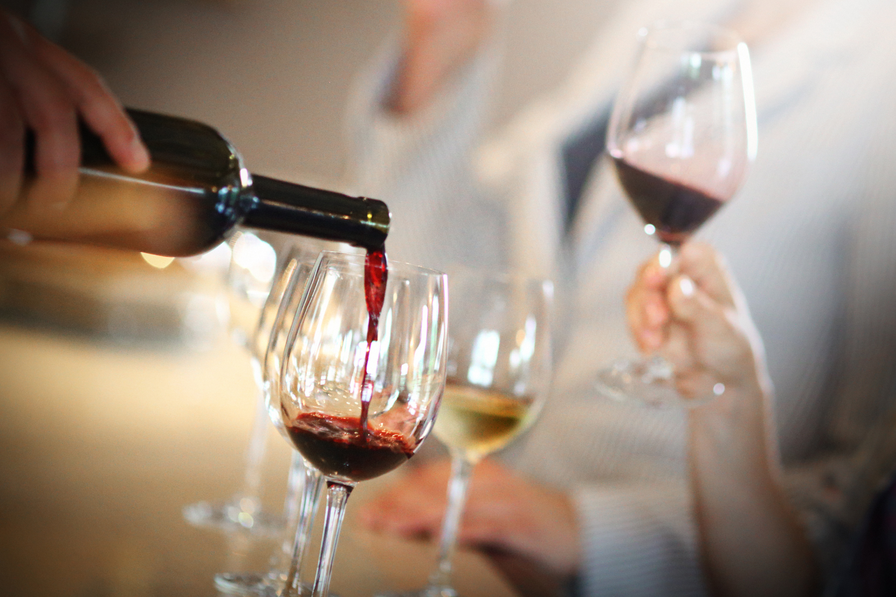 Red wine pouring at a tasting event.